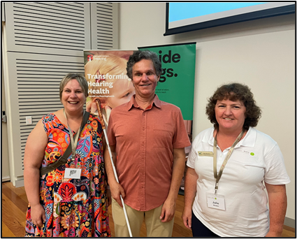 Julie and Alana with Daniel Kish are who is holding a cane are standing in a room at the Orientation and Mobility Association of Australia (OMAA) Conference in Sydney 2025.