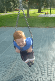 A child laying on their tummy on a in a playground.