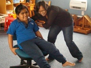 A learner is being spun by her teacher aide as part of her sensory development programme