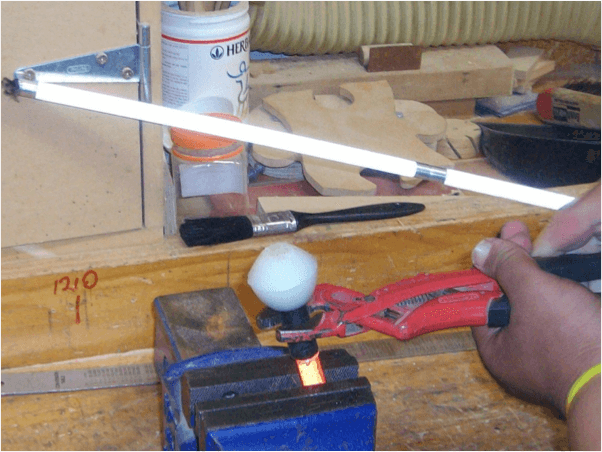 Cane tip wedged in a vice and using plyers to remove the tip.