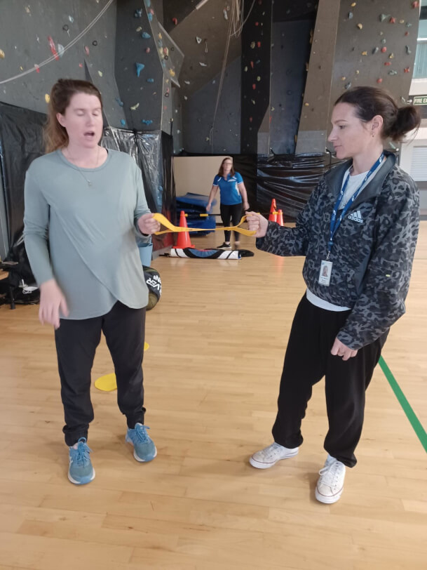 Casey from Blind Sport NZ modelling how to use the running tether with another person.