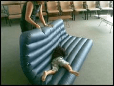 Child being rolled around on an airbed by O&M instructor.