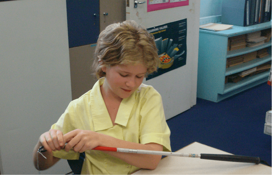 Jesse holding her cane pulling the cane fixing string out of the tip end.