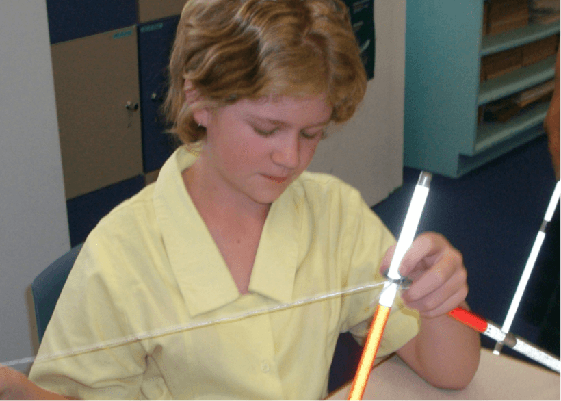 Jesse is tying the string part of her 'cane fixing kit' to the end of the elastic.
