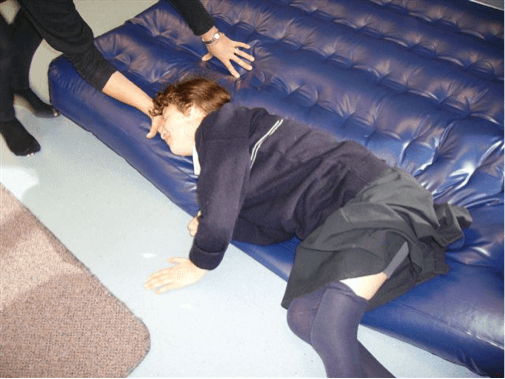 Sam lies on the edge of the airbed and the O & M specialist has her hand under her head.