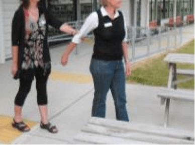 Sighted guide walking in front of guided person.