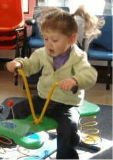 A young child playing on a spring rocker