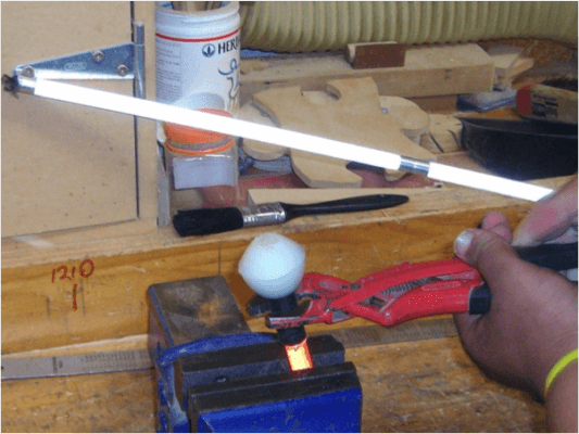 Cane tip wedged in a vice and using plyers to remove the tip