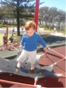 Child walking on a balancing trampoline at a playground