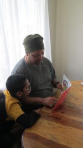 Dad and son sitting reading a book