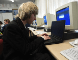 Student sitting in a computer suite working on a laptop
