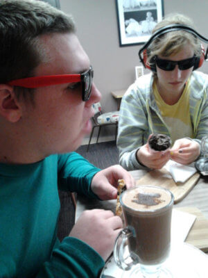 Two students sitting at table drinking hot chocolate
