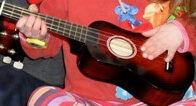 Child's hand on ukulele