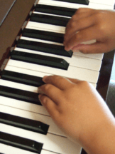 Child’s hands exploring piano keys