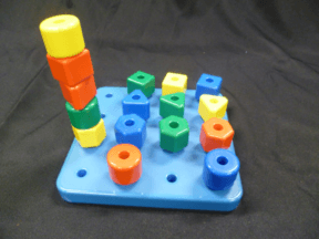 A set of four shapes in four colours to place into holes in a 4X4 board. Five of the pegs are stacked while the remainder are in individual holes