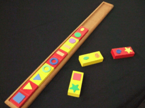 A set of wooden dominoes with tactile shapes and a long wooden tray to fit them into
