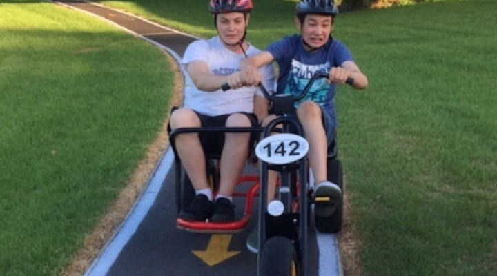 Two students riding a bike at Homai