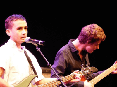 Jack and Benjamin playing guitars, microphone in front of Jack