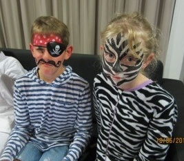 Two children one with a painted face and one dressed like a pirate