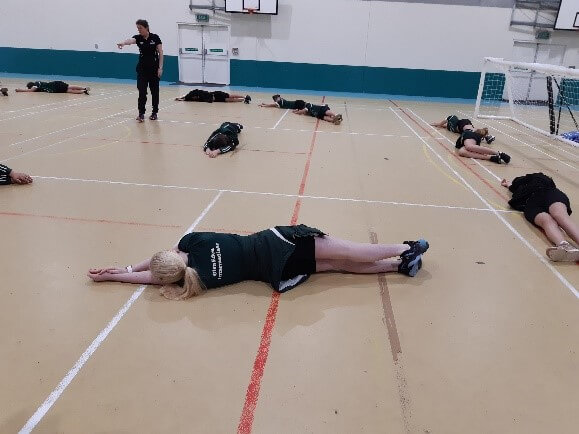 Figure 1 - Learners lying on the gym floor practising how to defend the goalball nets.