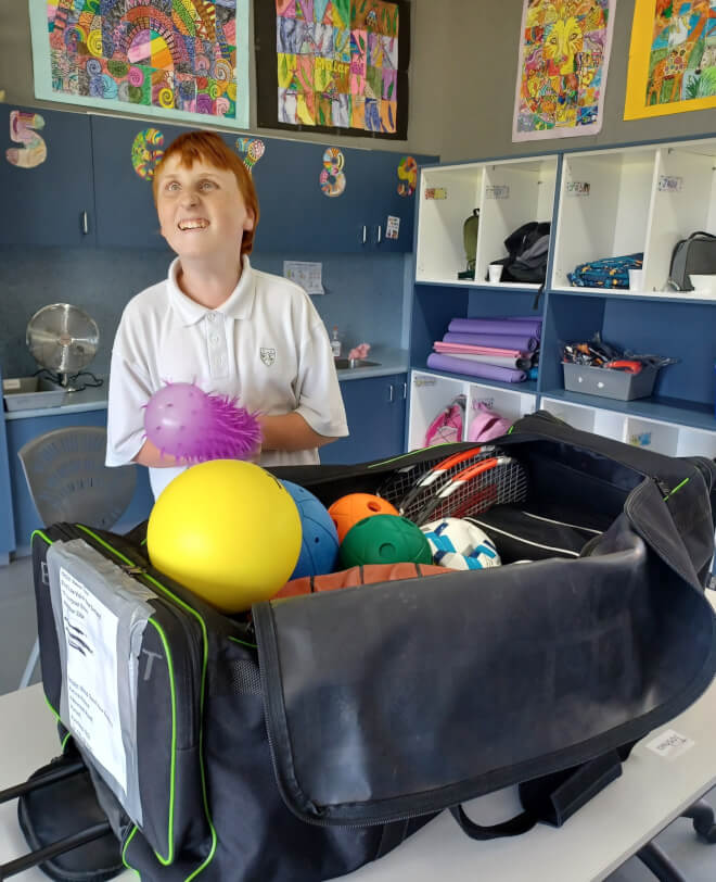 Figure 2 - Ākonga is holding a ball that was in the big bag with the sports equipment from Blind Sport NZ
