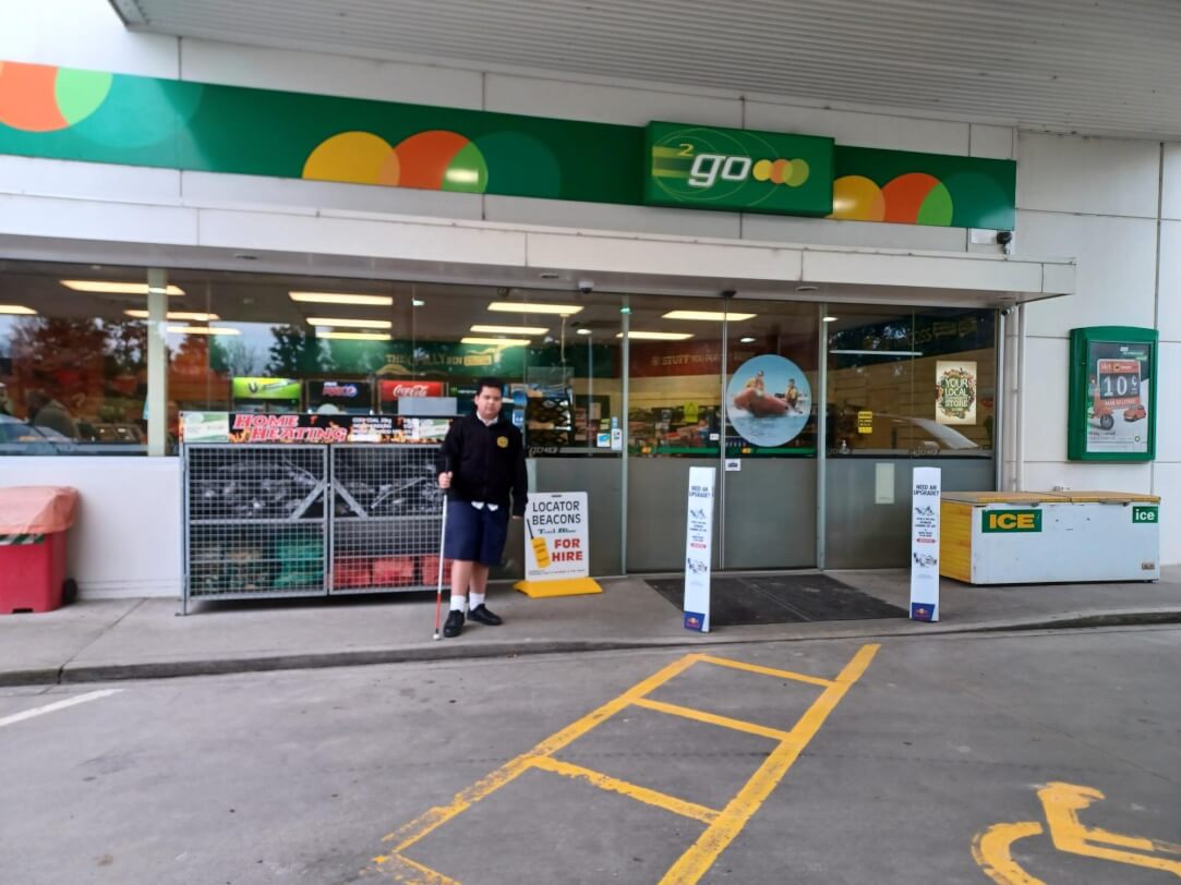 Figure 1 - Dimetruz is standing outside the BP petrol station with his cane where he is familiarising the space and surroundings in preparation for work experience there.